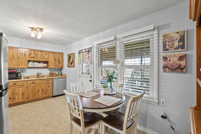 dining space featuring sink and a textured ceiling