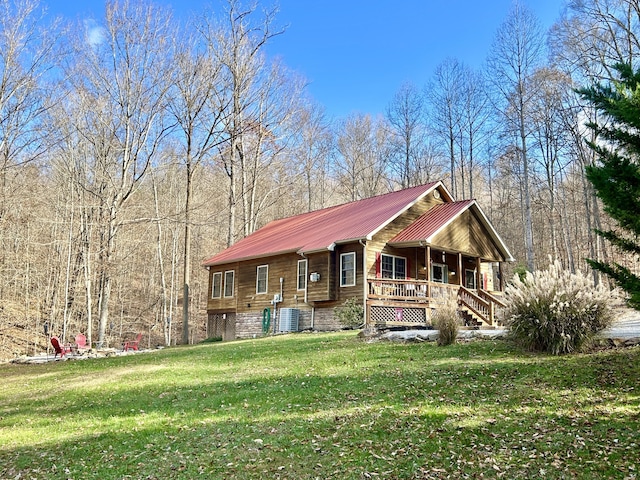 view of front of home featuring a porch, cooling unit, and a front yard