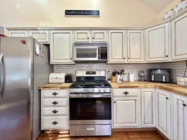 kitchen featuring dishwasher, sink, dark hardwood / wood-style flooring, wooden counters, and backsplash