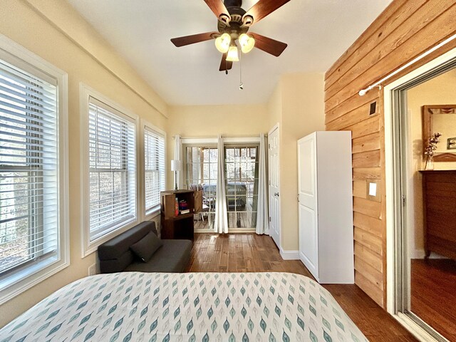 bedroom with dark hardwood / wood-style flooring and wood walls