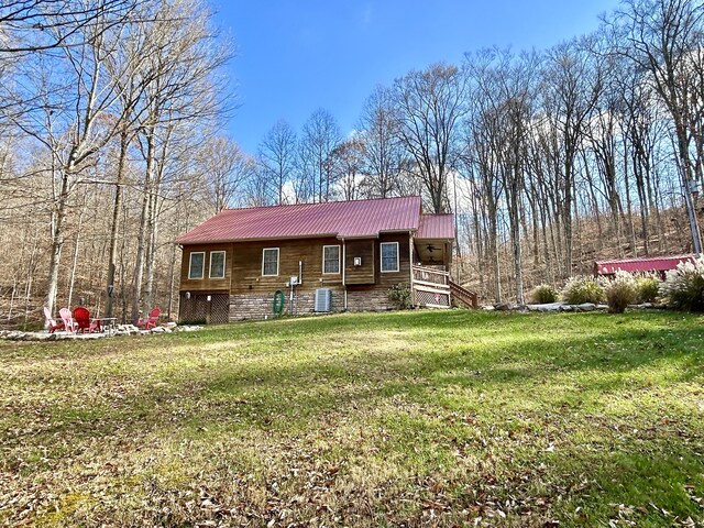 view of front of house with a front lawn and central AC unit