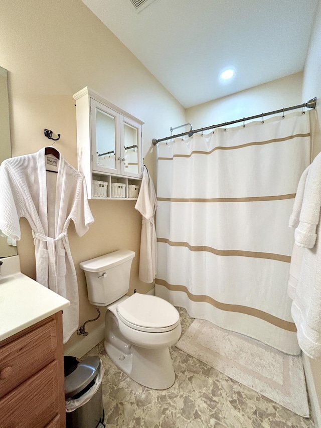 bathroom featuring walk in shower, vanity, and toilet