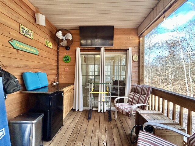 sunroom featuring ceiling fan, a healthy amount of sunlight, and wood ceiling