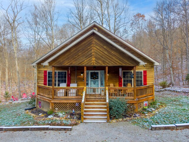 log cabin featuring covered porch