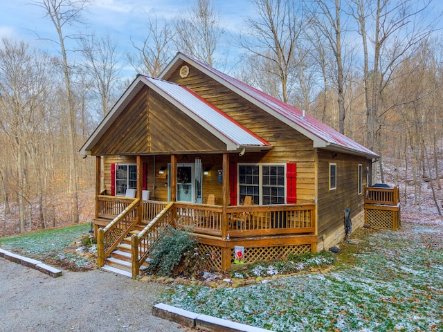 log home featuring covered porch