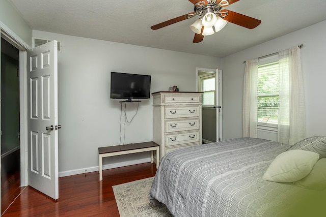 bedroom with dark hardwood / wood-style floors, ceiling fan, and a textured ceiling