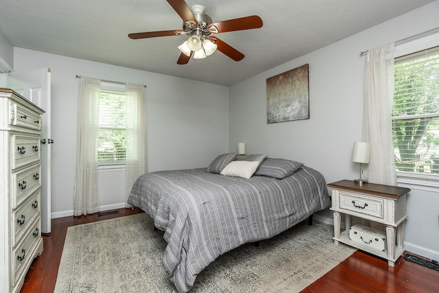 bedroom featuring a textured ceiling, dark hardwood / wood-style flooring, and ceiling fan