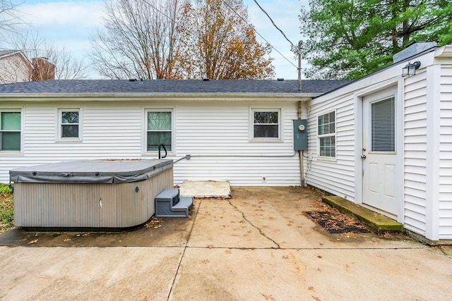 back of property featuring a hot tub and a patio area