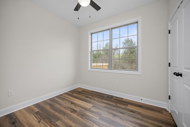 spare room with ceiling fan and dark wood-type flooring