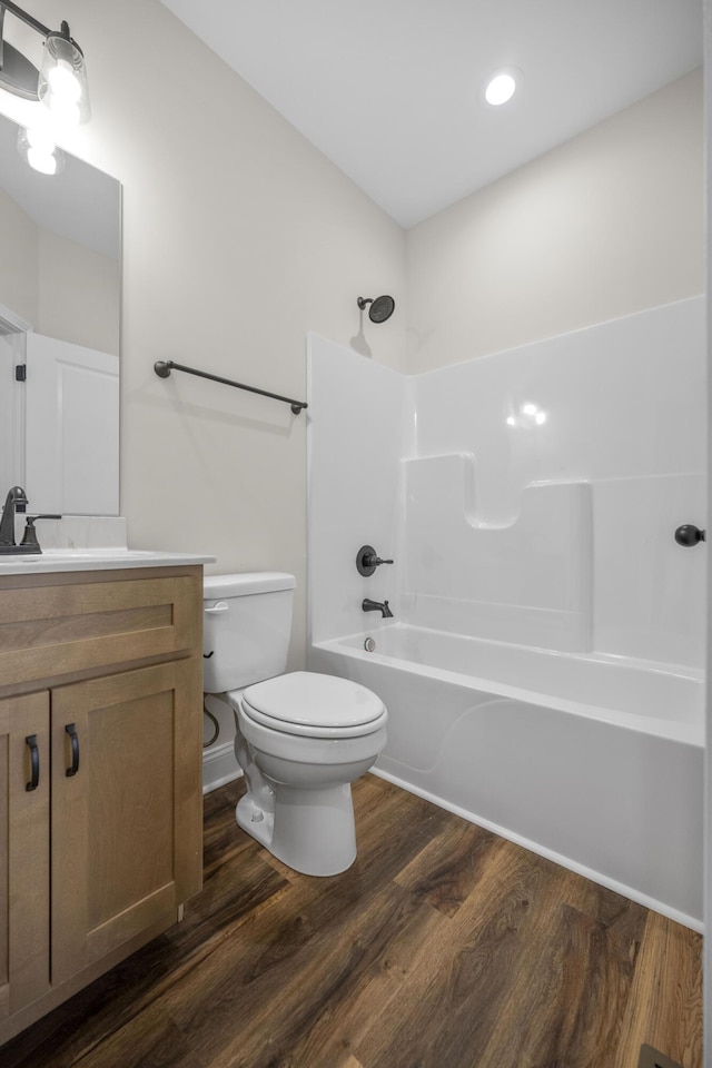 full bathroom featuring toilet, vanity, hardwood / wood-style flooring, and bathing tub / shower combination