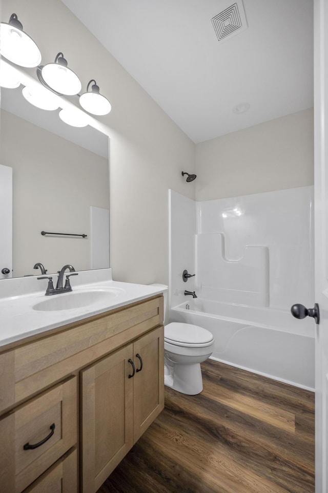 full bathroom featuring bathing tub / shower combination, vanity, wood-type flooring, and toilet