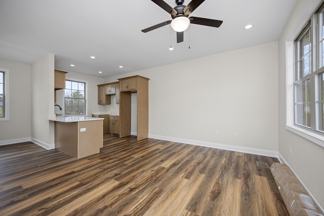 kitchen with kitchen peninsula, dark hardwood / wood-style flooring, ceiling fan, and sink