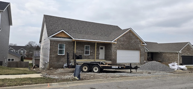 view of front facade featuring a garage, brick siding, and roof with shingles