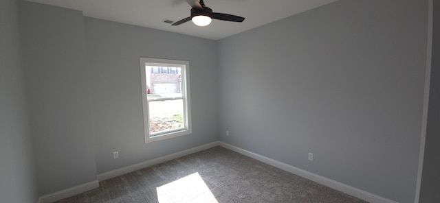 carpeted empty room with a ceiling fan and baseboards