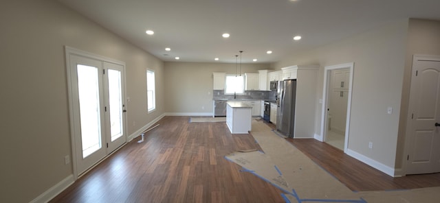 kitchen with backsplash, appliances with stainless steel finishes, wood finished floors, and a center island