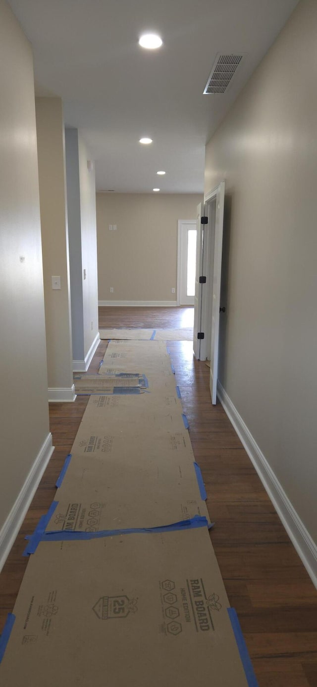 corridor with recessed lighting, visible vents, baseboards, and wood finished floors