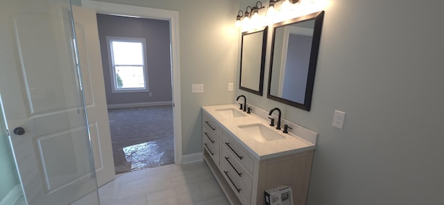 full bathroom featuring double vanity, tile patterned flooring, baseboards, and a sink