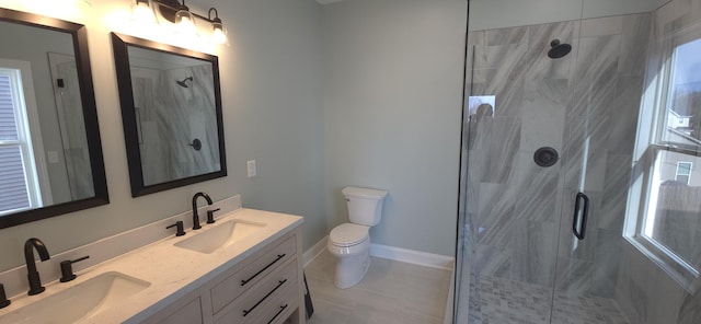 bathroom with a sink, toilet, double vanity, and a shower stall