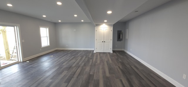 unfurnished room with recessed lighting, baseboards, electric panel, and dark wood-style flooring