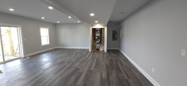 spare room with dark wood-type flooring, recessed lighting, and baseboards