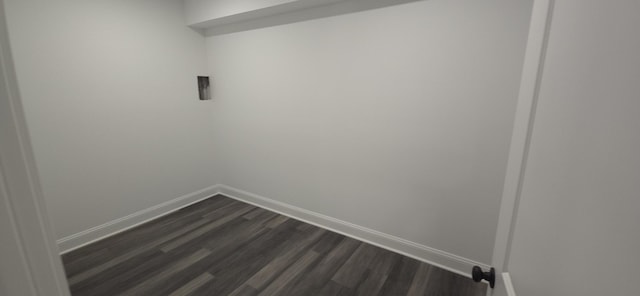 unfurnished room featuring baseboards and dark wood finished floors