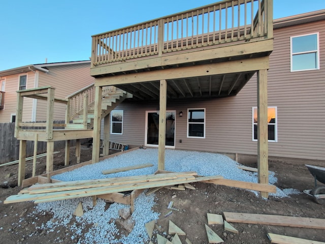 rear view of house featuring a deck and stairs