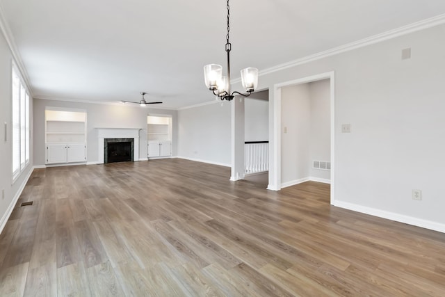 unfurnished living room with a fireplace, crown molding, and wood finished floors