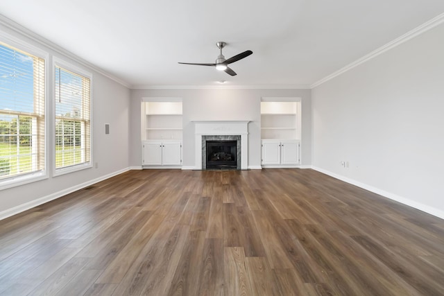 unfurnished living room with ornamental molding, dark wood-type flooring, a premium fireplace, and baseboards