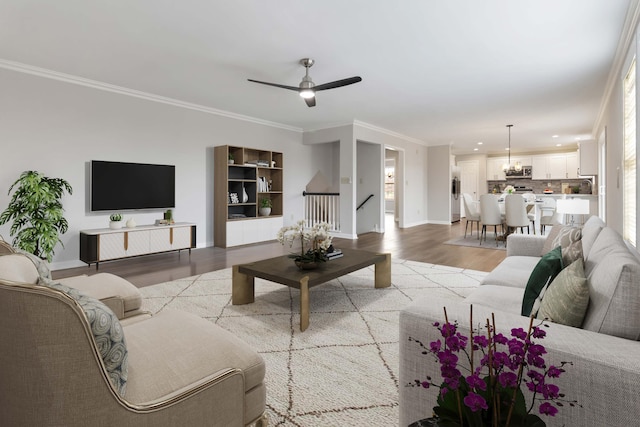 living area with crown molding, ceiling fan, baseboards, recessed lighting, and light wood-style floors