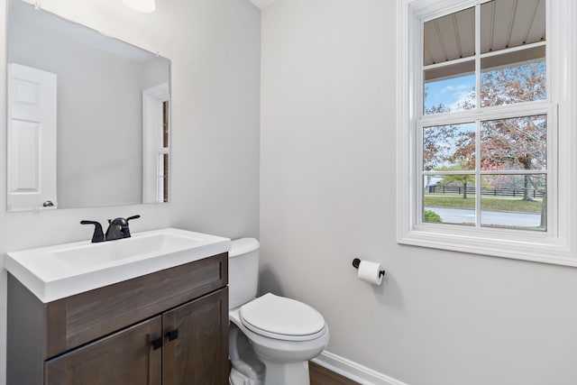 bathroom with vanity, toilet, and baseboards