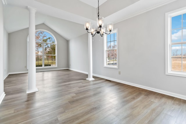 unfurnished dining area featuring decorative columns and wood finished floors