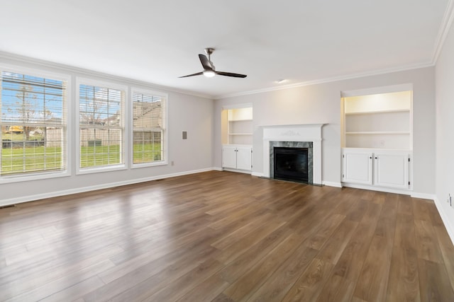 unfurnished living room featuring dark wood-style floors, a fireplace, baseboards, and crown molding