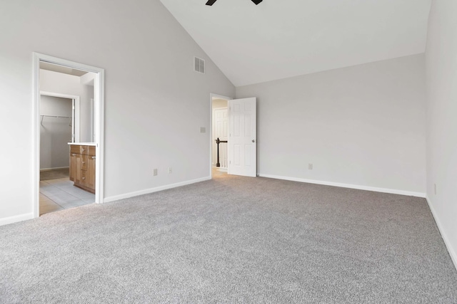 unfurnished bedroom with high vaulted ceiling, baseboards, visible vents, and light colored carpet