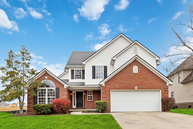 traditional-style home featuring a shingled roof, concrete driveway, a front lawn, a garage, and brick siding