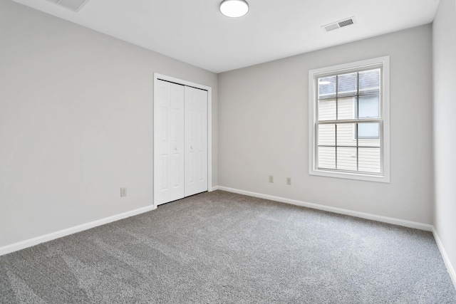 unfurnished bedroom with carpet, a closet, visible vents, and baseboards