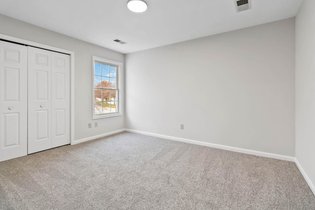 unfurnished bedroom with carpet floors, baseboards, and visible vents