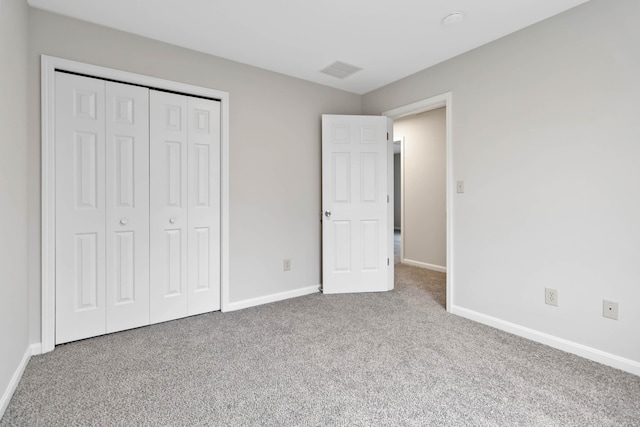 unfurnished bedroom with carpet floors, a closet, visible vents, and baseboards