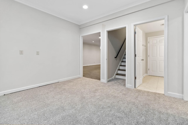 carpeted empty room featuring stairs, crown molding, recessed lighting, and baseboards