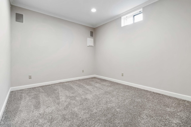 below grade area with carpet, visible vents, ornamental molding, and baseboards