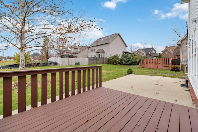 wooden terrace with a residential view, a patio area, a yard, and fence