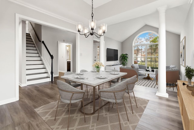 dining area featuring a notable chandelier, decorative columns, stairway, and wood finished floors