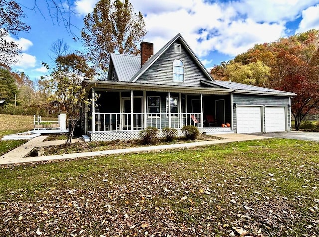 farmhouse inspired home with covered porch, a front yard, and a garage