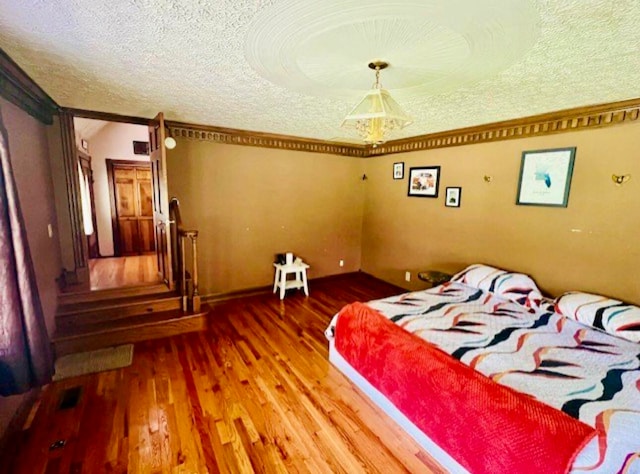 bedroom with a textured ceiling and hardwood / wood-style flooring