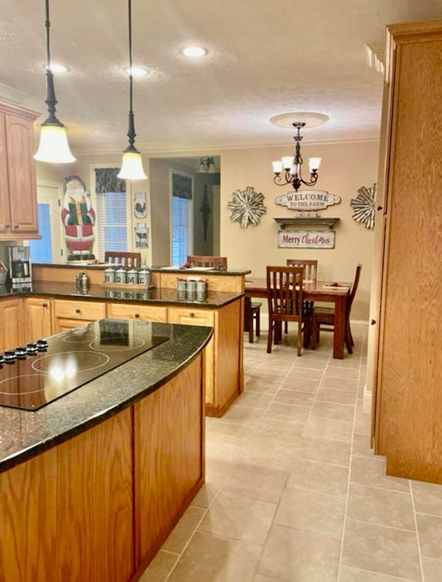 kitchen with decorative light fixtures, black electric cooktop, ornamental molding, light tile patterned floors, and a notable chandelier