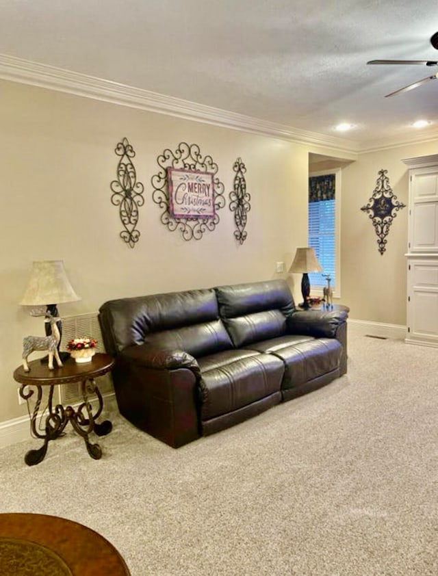 carpeted living room with ceiling fan and ornamental molding