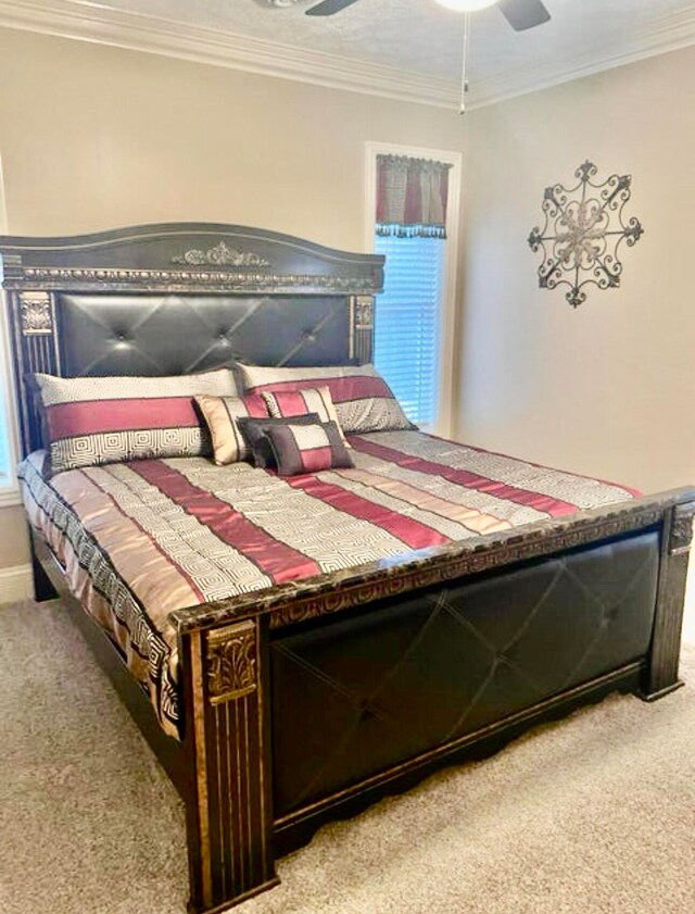 bedroom featuring light colored carpet, ceiling fan, and ornamental molding