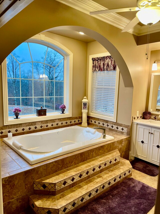 bathroom with vanity, crown molding, and tiled tub