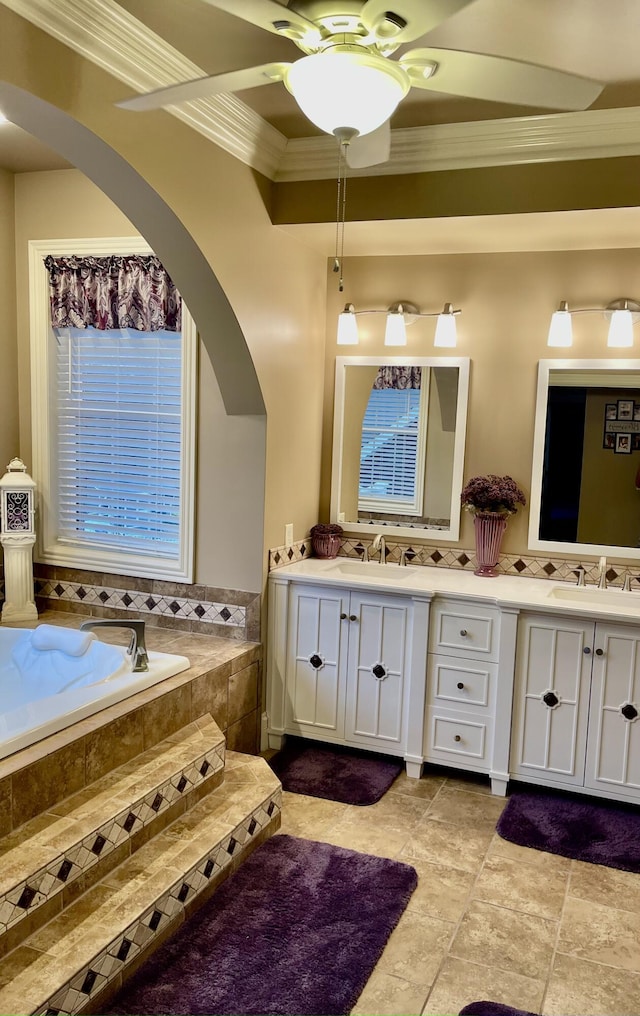 bathroom featuring vanity, a relaxing tiled tub, and ornamental molding