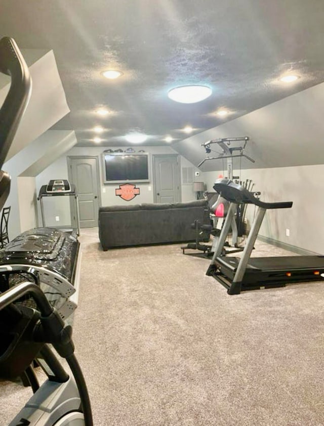 exercise room with a textured ceiling, light carpet, and vaulted ceiling