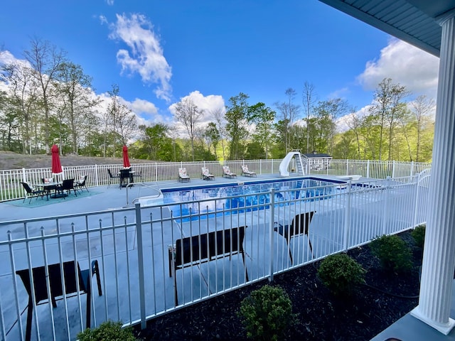 view of swimming pool featuring a water slide and a patio